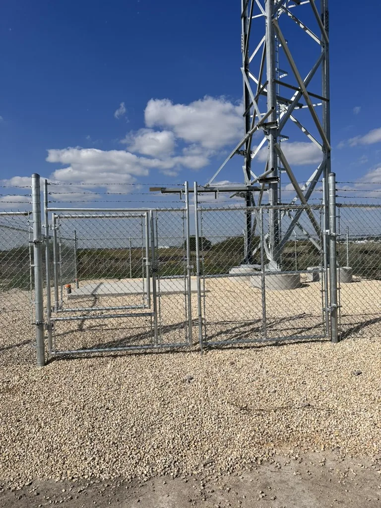 Security gate with barbed wire topping