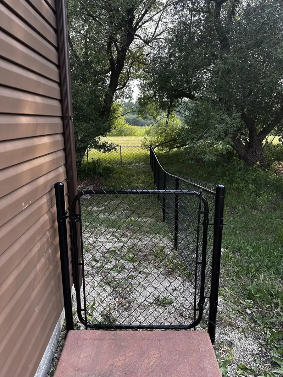 Black chain link walk gate with a rounded frame